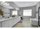 This Primary bathroom includes a soaking tub, large window, and dual vanities at 5812 Shangri La Night Ct, Las Vegas, NV 89149