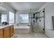 Bright bathroom features soaking tub next to glass enclosed shower with stone pebble floor at 6220 Silver Edge St, North Las Vegas, NV 89031