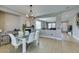 Stylish dining room with modern lighting fixture, and an adjacent living area at 6220 Silver Edge St, North Las Vegas, NV 89031
