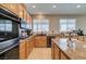 Well-lit kitchen with granite countertops, stainless steel appliances, and ample cabinet space for storage at 6220 Silver Edge St, North Las Vegas, NV 89031