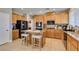 Well-equipped kitchen with stainless steel appliances, granite countertops, an island with seating, and wood cabinets at 6220 Silver Edge St, North Las Vegas, NV 89031