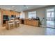 Well-lit kitchen with wood cabinetry, a central island with seating, and easy access to the outdoor pool area at 6220 Silver Edge St, North Las Vegas, NV 89031