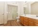 Bright bathroom featuring a glass-enclosed shower, double sink vanity, and wood-look flooring at 6700 Amarinta Ave # 104, Las Vegas, NV 89108