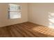 Bright bedroom with wood-look floors, a large window, and ample natural light at 6700 Amarinta Ave # 104, Las Vegas, NV 89108
