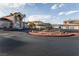 Community entrance featuring a circle driveway, mature desert landscaping, and covered entrance at 6700 Amarinta Ave # 104, Las Vegas, NV 89108