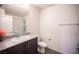 Well-lit bathroom featuring a granite countertop, dark wood cabinets, and modern fixtures at 6913 Evening Orchid St, North Las Vegas, NV 89086
