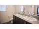 Modern bathroom with double sinks, granite countertop, dark wood cabinets, and contemporary fixtures at 6913 Evening Orchid St, North Las Vegas, NV 89086