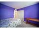 Bedroom with bright purple walls, carpeted floors, and access to ensuite at 6913 Evening Orchid St, North Las Vegas, NV 89086