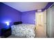 Comfortable bedroom with bright purple walls, carpeted floors and access to ensuite at 6913 Evening Orchid St, North Las Vegas, NV 89086