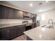 Contemporary kitchen featuring stainless steel appliances, granite counters, and sleek dark wood cabinets at 6913 Evening Orchid St, North Las Vegas, NV 89086