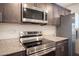 Modern kitchen with stainless steel appliances, granite countertops and dark wood cabinetry at 6913 Evening Orchid St, North Las Vegas, NV 89086