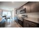 Modern kitchen featuring stainless steel appliances, granite countertops, and dark wood cabinetry at 6913 Evening Orchid St, North Las Vegas, NV 89086