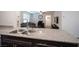 Bright kitchen features stainless steel sink and granite countertop bar, overlooking the living space at 6913 Evening Orchid St, North Las Vegas, NV 89086
