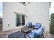 Charming outdoor patio setup with a comfortable lounge area and sliding glass door at 6913 Evening Orchid St, North Las Vegas, NV 89086