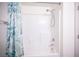 Bright shower with a white tile surround, adjustable shower head, and green floral shower curtain at 6913 Evening Orchid St, North Las Vegas, NV 89086