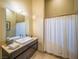 Bright bathroom features a modern vanity, stylish mirror, and a pristine shower curtain creating a clean and functional space at 7430 Yonie Ct, Las Vegas, NV 89117