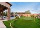Lush backyard featuring a refreshing pool with a charming waterfall, a putting green, and a comfortable outdoor seating area at 7682 Rafter Ct, Las Vegas, NV 89139
