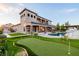Expansive backyard featuring a pool, rock waterfall, putting green, and beautifully landscaped lawn at 7682 Rafter Ct, Las Vegas, NV 89139