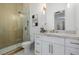 Elegant bathroom featuring a glass-enclosed shower, marble countertops, and stylish white cabinetry at 7682 Rafter Ct, Las Vegas, NV 89139
