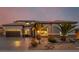Inviting home exterior with a two-car garage, desert landscaping, and warm exterior lighting at 7682 Rafter Ct, Las Vegas, NV 89139