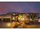 Elegant exterior with desert landscaping, warm lighting, a spacious driveway, and solar panels to add curb appeal at 7682 Rafter Ct, Las Vegas, NV 89139
