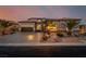Inviting exterior features desert landscaping, warm lighting, and a spacious driveway that adds to the property's appeal at 7682 Rafter Ct, Las Vegas, NV 89139