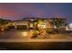 Stunning exterior showcases desert landscaping, a large driveway, and warm lighting enhancing the home's curb appeal at 7682 Rafter Ct, Las Vegas, NV 89139