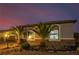 Charming exterior features desert landscaping, warm lighting, and lovely architectural details that enhance the home's facade at 7682 Rafter Ct, Las Vegas, NV 89139