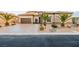 Inviting exterior features desert landscaping, warm lighting, and a spacious driveway that adds to the property's appeal at 7682 Rafter Ct, Las Vegas, NV 89139