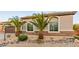 Charming single-story home featuring a desert landscaped front yard with decorative rock and palm trees at 7682 Rafter Ct, Las Vegas, NV 89139