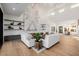 Open concept living room with white sofas, wood floors, and a statement marble accent wall at 7682 Rafter Ct, Las Vegas, NV 89139
