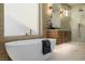 Soaking tub in bathroom features gold fixtures, modern design, and tiled walls at 7682 Rafter Ct, Las Vegas, NV 89139