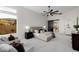 Bright main bedroom with sitting area, plush carpet, large windows, and modern ceiling fan at 7682 Rafter Ct, Las Vegas, NV 89139