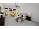 Bright main bedroom features sitting area, soft carpet, large windows, and modern ceiling fan at 7682 Rafter Ct, Las Vegas, NV 89139
