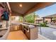 Well-equipped outdoor kitchen featuring a grill, counter space, and stainless steel appliances, ideal for backyard barbecues at 7682 Rafter Ct, Las Vegas, NV 89139
