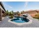 Stunning backyard features a pool with a waterfall, hot tub and covered patio, perfect for entertaining at 7682 Rafter Ct, Las Vegas, NV 89139