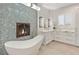 Bright bathroom featuring a soaking tub next to a fireplace and a double vanity with marble counters at 8455 Stange Ave, Las Vegas, NV 89129