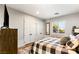 Comfortable bedroom with a plaid bedspread, dresser with TV, and a window with plantation shutters at 8455 Stange Ave, Las Vegas, NV 89129