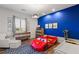 Fun themed bedroom with modern furniture, ample natural light, and an eye-catching blue accent wall at 8455 Stange Ave, Las Vegas, NV 89129
