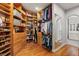 Walk-in closet with custom wood shelving, drawers, and hanging rods with mirror and open to bathroom at 8455 Stange Ave, Las Vegas, NV 89129