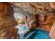 Stunning grotto featuring rock walls, a cascading waterfall, and a relaxing spa, creating a private oasis at 8455 Stange Ave, Las Vegas, NV 89129