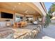 Covered outdoor patio featuring a dining area, TV, built-in grill, and comfortable seating, perfect for entertaining guests at 8455 Stange Ave, Las Vegas, NV 89129