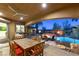 Covered patio features a dining area, ceiling fan and overlooks the beautiful pool and outdoor fireplace at 8455 Stange Ave, Las Vegas, NV 89129