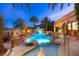 Beautiful outdoor pool area featuring a waterfall, fire pit, and lush landscaping, perfect for relaxation and entertaining at 8455 Stange Ave, Las Vegas, NV 89129