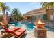 Luxurious backyard featuring a dazzling pool, cascading waterfall, and ample lounge space, ideal for relaxation and entertainment at 8455 Stange Ave, Las Vegas, NV 89129