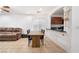 Open-concept dining area with wood table, tile flooring, and view into the kitchen at 9132 Gabardine Ave, Las Vegas, NV 89149