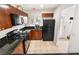 Traditional kitchen with granite countertops, tile floors, and a black refrigerator and gas oven at 9132 Gabardine Ave, Las Vegas, NV 89149