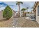 Backyard featuring desert landscaping, including palm trees and patio set at 9844 Altadena St, Las Vegas, NV 89183