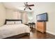 Bedroom with hardwood flooring features ceiling fan and dresser with television at 9844 Altadena St, Las Vegas, NV 89183