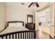 A cozy bedroom featuring a ceiling fan, dark wood furniture, and an adjoining dining area at 9844 Altadena St, Las Vegas, NV 89183